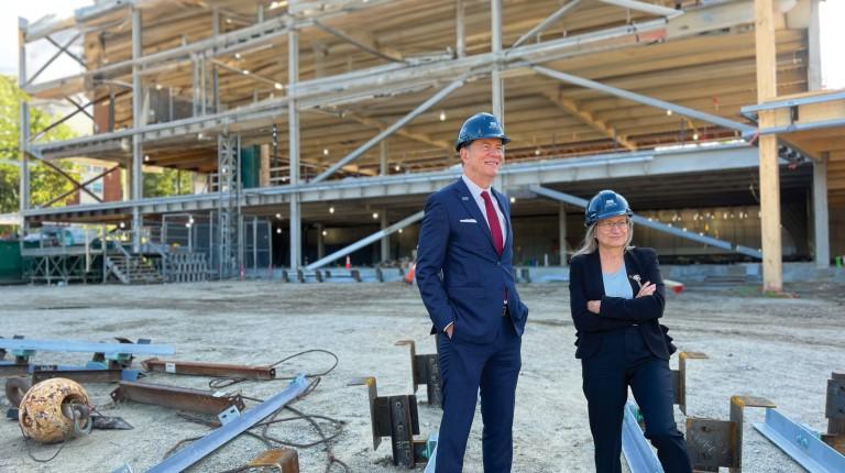 U N E President James Herbert and the College of Osteopathic Medicine dean stand in front of the construction of the Harold and Bibby Center for Health Sciences