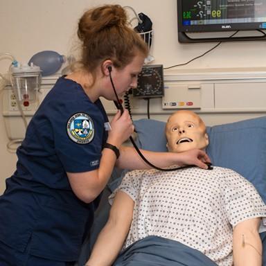 A nursing student working in the sim lab
